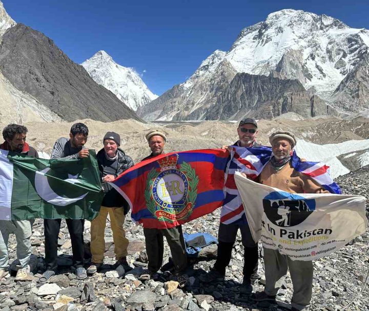 K2 Base Camp trekking. Group is at Concordia raising flag and backdrop is K2